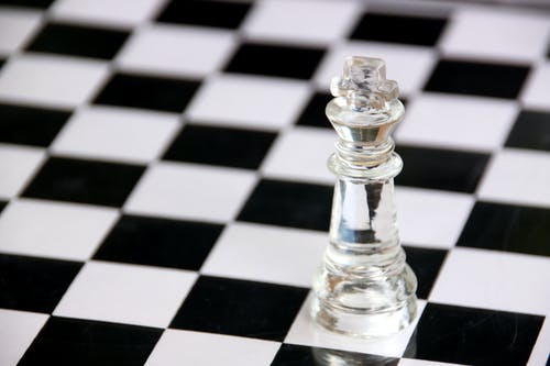 黑色和白色格仔桌上的透明玻璃国际象棋棋子 · 免费素材图片