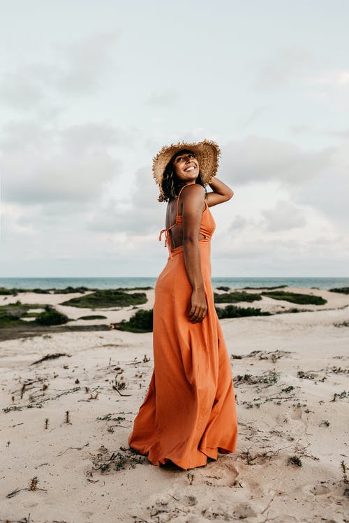 女人穿着橙色的衣服和太阳帽 · 免费素材图片