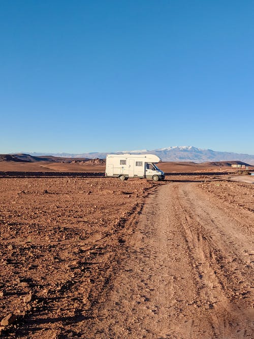 土路上的白色露营车 · 免费素材图片