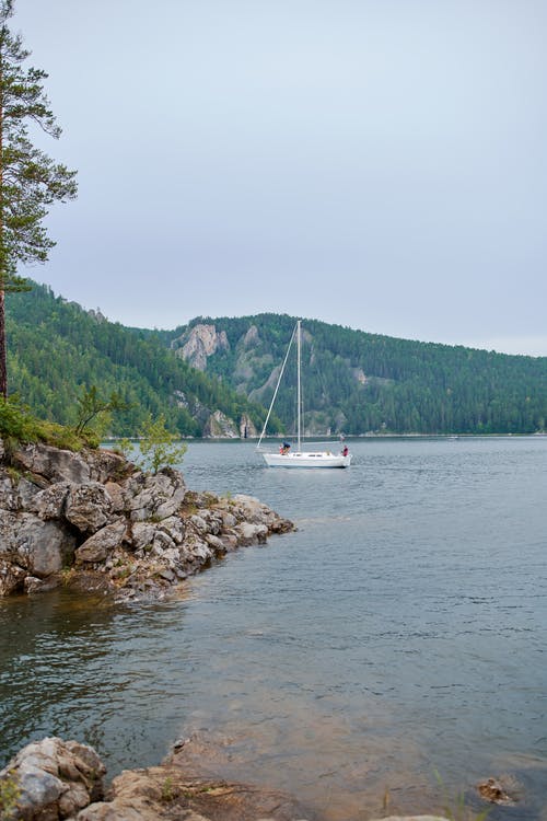 孤独的帆船在海边附近的水中 · 免费素材图片