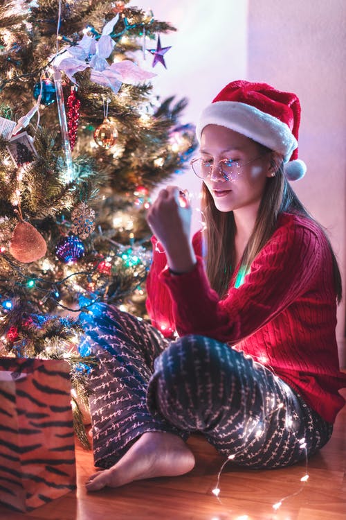 坐在圣诞树旁边的女人 · 免费素材图片