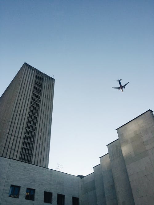 飞机飞越建筑物的低角度照片 · 免费素材图片