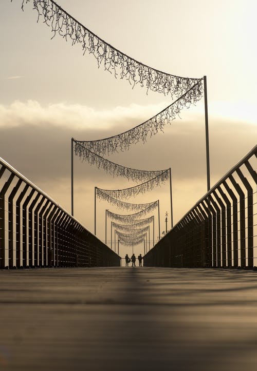 三人站在桥上的剪影 · 免费素材图片