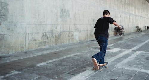 十几岁的男孩在市区骑滑板 · 免费素材图片