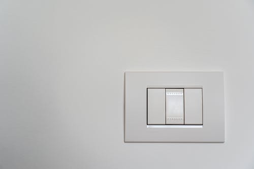 白漆墙上的白灯开关 · 免费素材图片