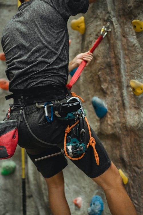 挂在攀岩墙附近的安全绳上无法辨认的男技师 · 免费素材图片