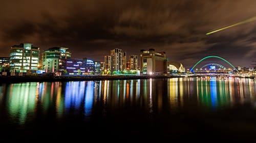 夜间反映在水体上的城市景观 · 免费素材图片