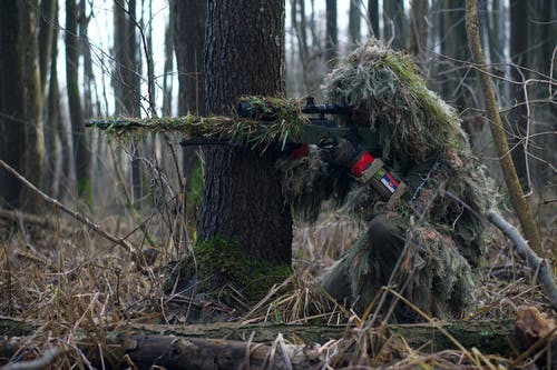 瞄准森林中步枪范围的士兵狙击手 · 免费素材图片