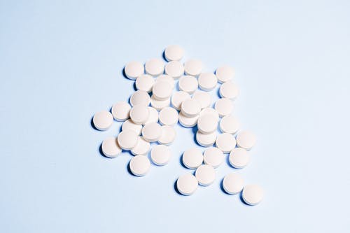 天蓝色表面上的白色圆形药物 · 免费素材图片