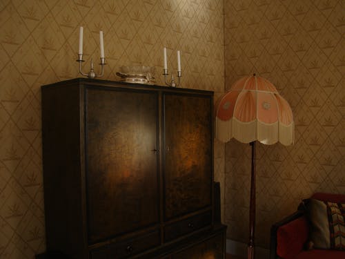 房间内有黑色木制衣柜和白色和粉红色基座灯 · 免费素材图片