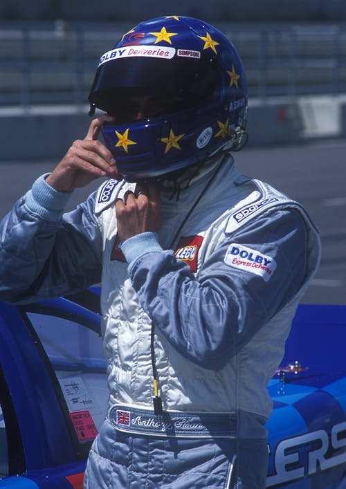 蓝色和白色的赛车服，戴着他的蓝色和黄色的星星全盔的男人 · 免费素材图片
