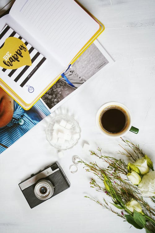 咖啡杯旁边的日记照片 · 免费素材图片