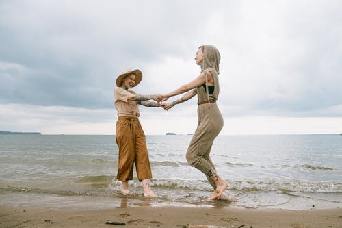 站在海滩上的妇女的照片 · 免费素材图片