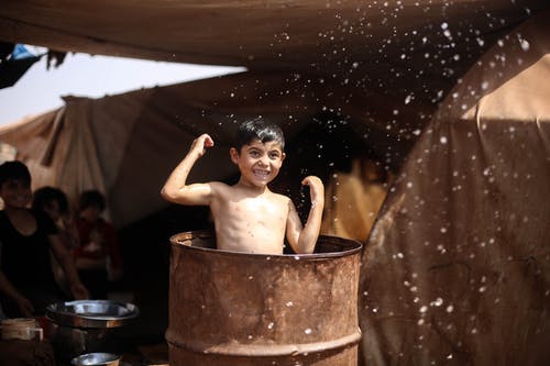 裸照的男孩坐在棕色木桶 · 免费素材图片