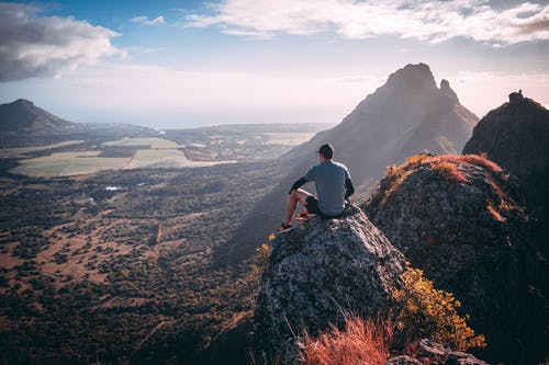 坐在落矶山脉的灰色衬衫的男人 · 免费素材图片