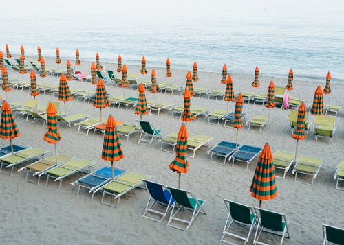 阳伞和沙滩椅在海边的沙滩上 · 免费素材图片