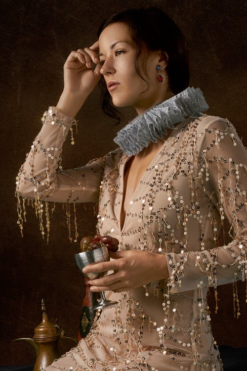 拿着金属杯子的棕色礼服的妇女 · 免费素材图片