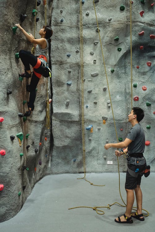 登山者在攀岩墙上一起训练与保护 · 免费素材图片