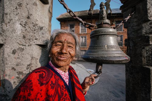 老教堂钟附近微笑高级印度女人 · 免费素材图片