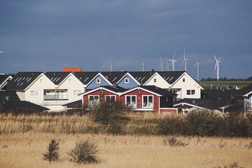 灰色的天空下的棕色草地上的白色和红色房子 · 免费素材图片