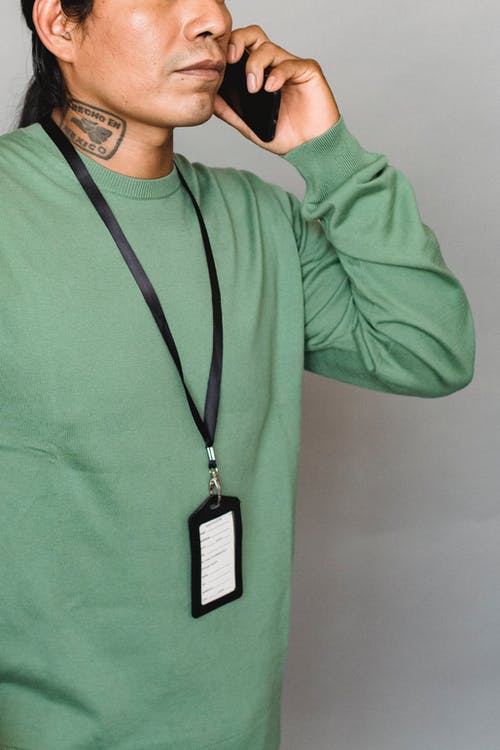 谈到智能手机灰色墙附近的民族男子 · 免费素材图片