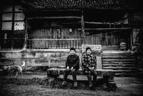 两人坐在长椅上的灰度照片 · 免费素材图片