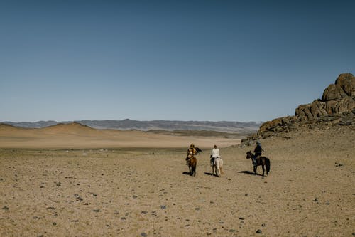 无法认出的骑兵在贫瘠的山谷骑马 · 免费素材图片