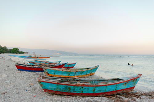 小船在海边游泳的游客在海滩上 · 免费素材图片