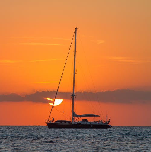 在日落期间在水体上的帆船 · 免费素材图片