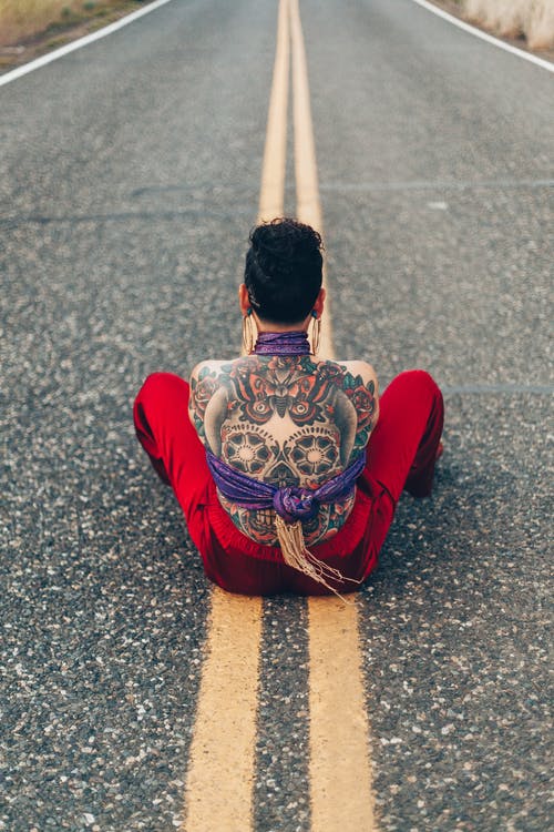 卡拉维拉纹身的人坐在马路中间 · 免费素材图片