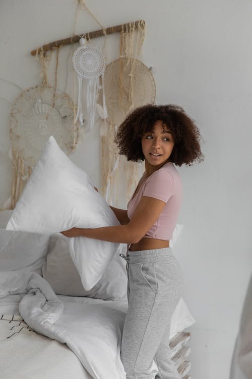 黑人妇女在早上铺床 · 免费素材图片