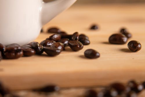棕色木制的桌子上的黑咖啡豆 · 免费素材图片