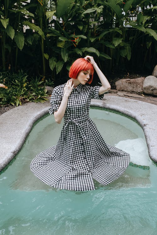 礼服站立在水池的敏感妇女 · 免费素材图片
