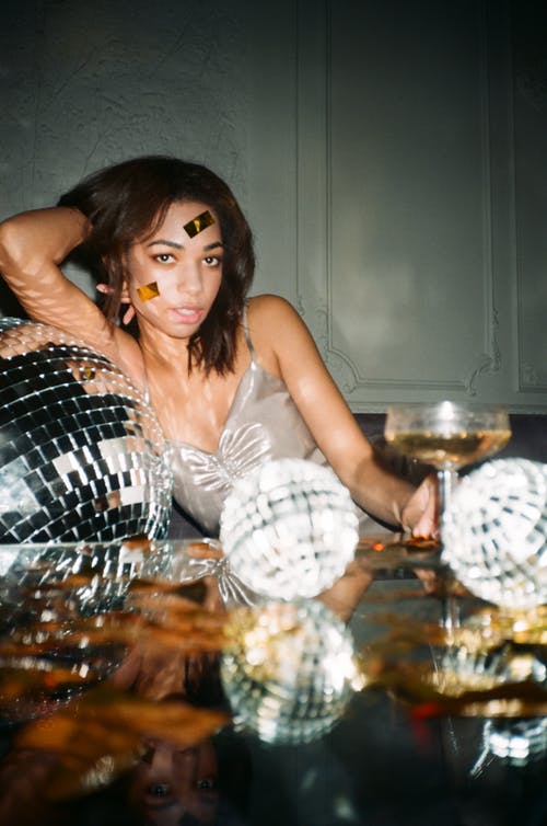 灰色的上衣的女人倾斜到镜子球 · 免费素材图片