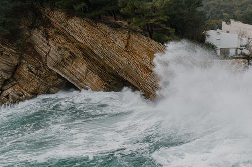 泡沫海浪猛撞在岩石峭壁上 · 免费素材图片