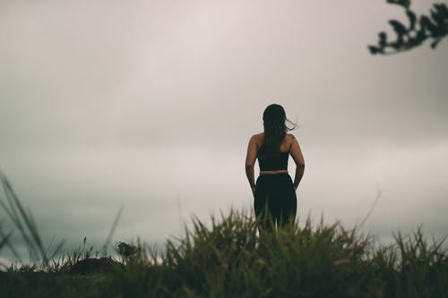黑色背心站在绿草地上的女人 · 免费素材图片