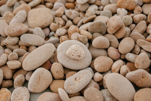 在白天的海滩上粗糙的灰色石头 · 免费素材图片
