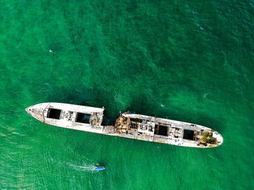 白船残骸在水面上 · 免费素材图片