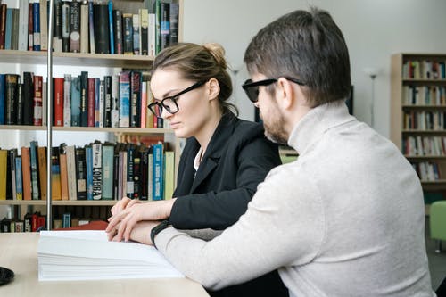 女人把男人的手放在书上 · 免费素材图片