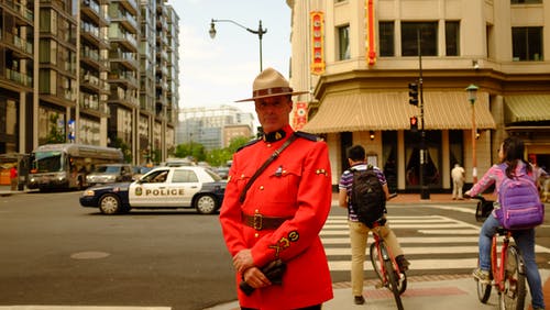 穿着制服站在人行道上的男人 · 免费素材图片