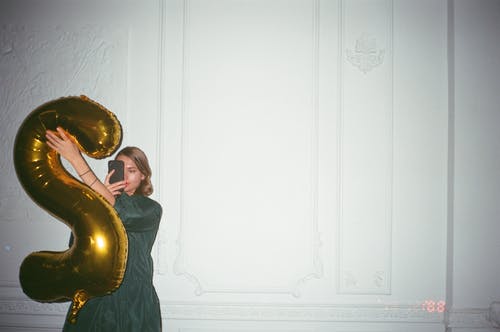 倚在墙上使用智能手机的女人 · 免费素材图片