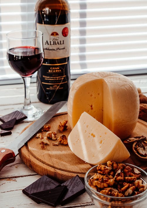 奶酪和红酒在棕色木砧板上 · 免费素材图片