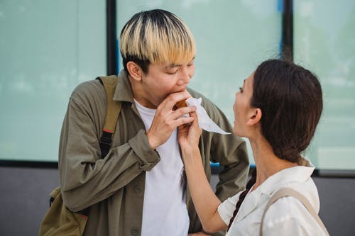 亚洲女人手喂男友与热狗 · 免费素材图片