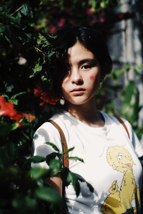 女人站在叶子附近 · 免费素材图片