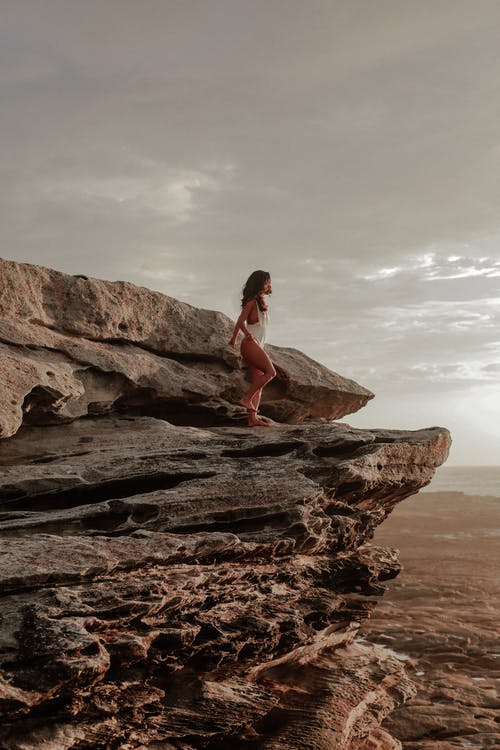 女人站在岩石上 · 免费素材图片