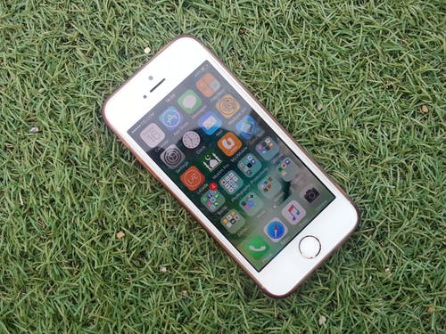 在绿色草地上的银色iphone · 免费素材图片