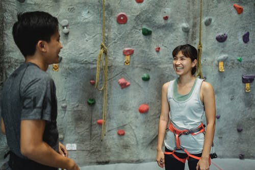 微笑的教练在练习之前与亚洲登山者交谈 · 免费素材图片