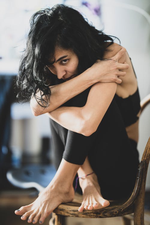 女人坐在棕色的拉坦椅子上 · 免费素材图片