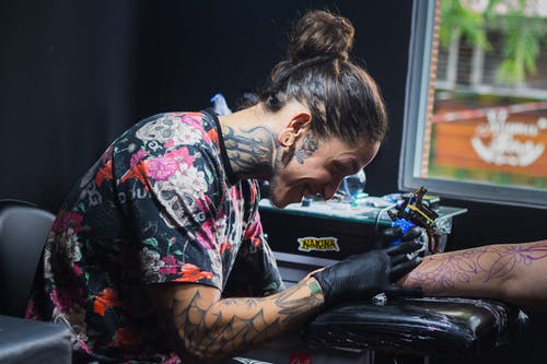 女人纹身另一个人的手臂 · 免费素材图片