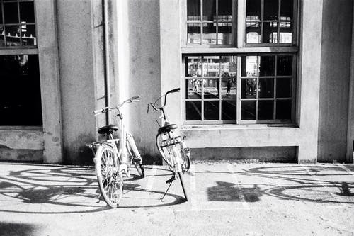 自行车停在混凝土建筑物附近的人行道上 · 免费素材图片